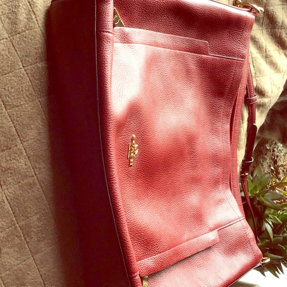 Beautiful red Coach purses with side pouches.